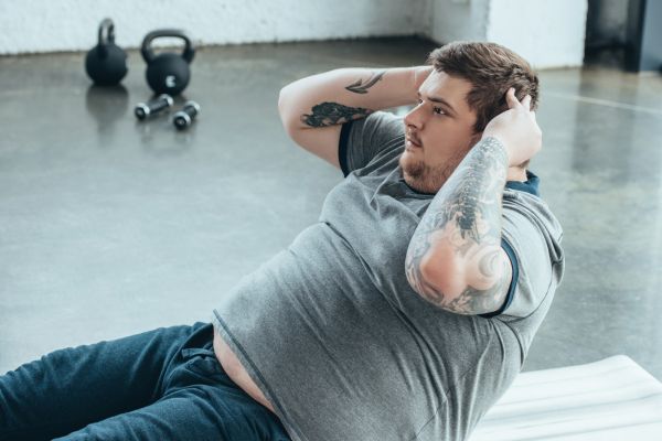Übergewichtiger Mann macht Sit-ups