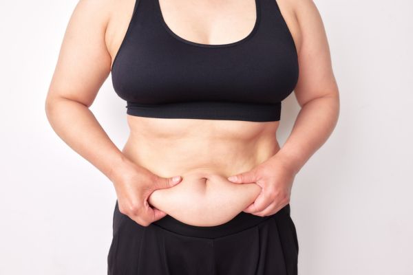 Frau hält ihre Bauchfalte